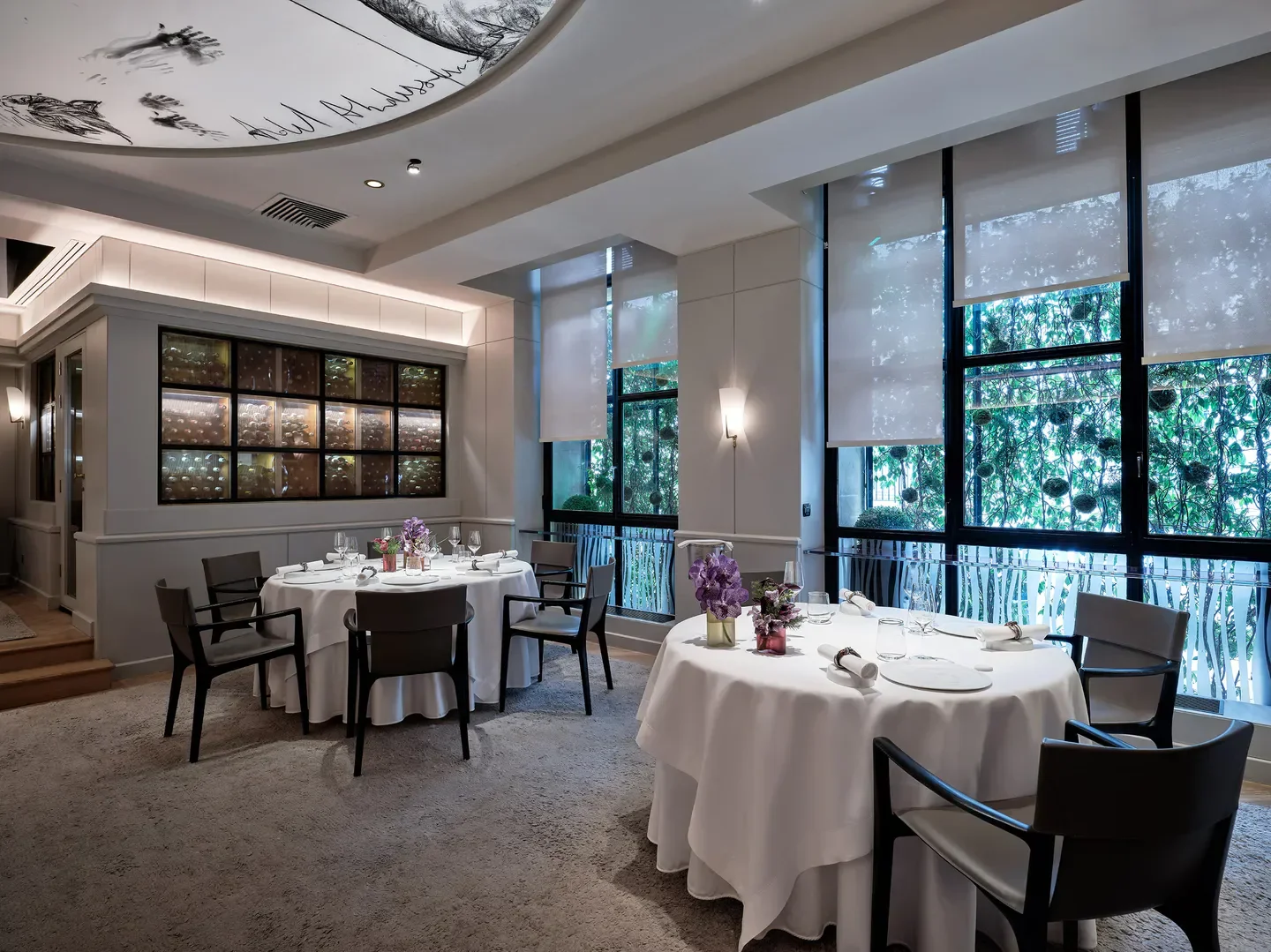 Elegant dining room at Pierre Gagnaire in Paris, with tables set for a meal.
