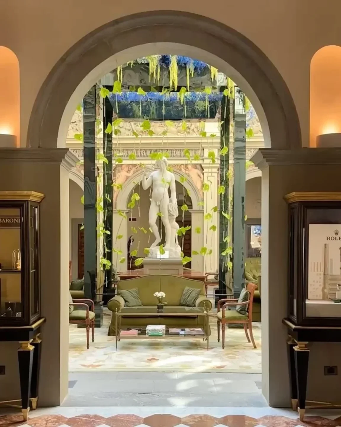 PIGNETO Four Seasons Tokyo: Elegant lounge with statue, hanging greenery, and plush seating.