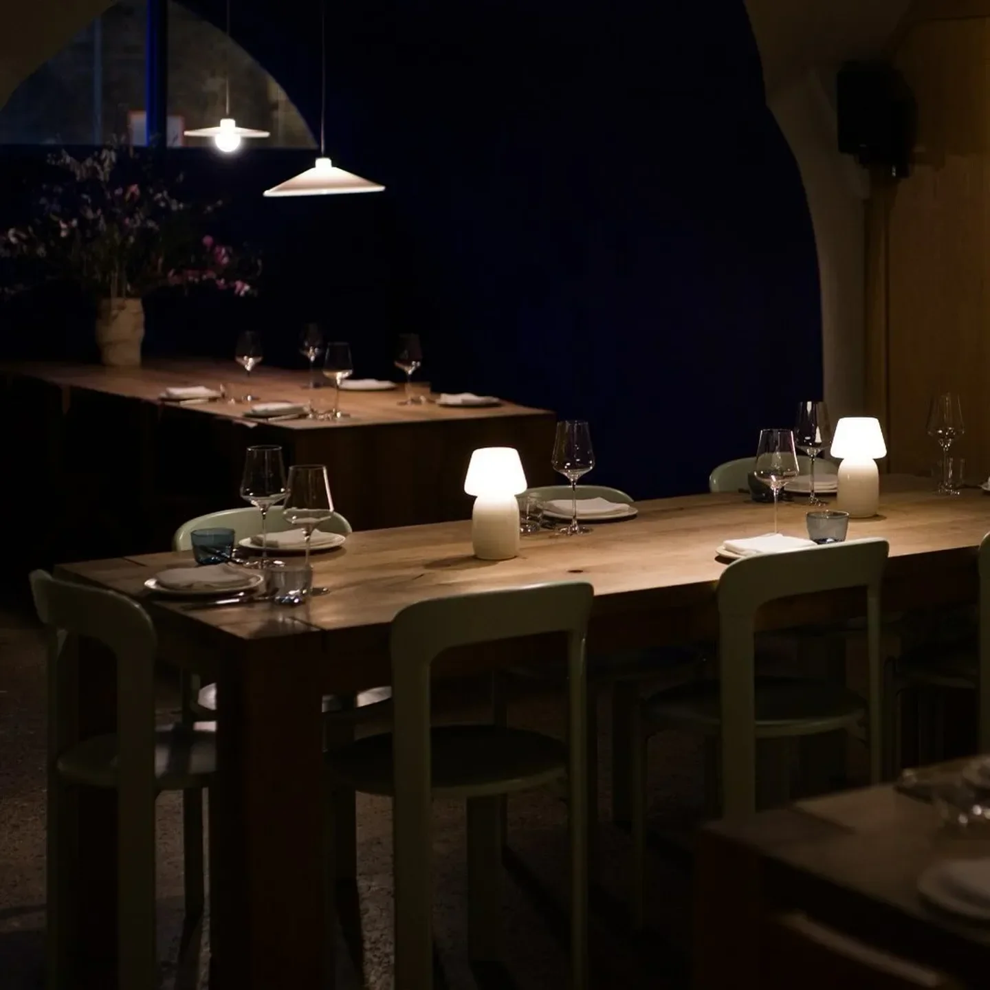 Planque London: cozy restaurant interior with wooden tables and soft lighting.