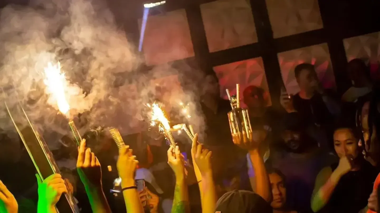 Celebration at Play Room nightclub in Philadelphia with sparklers and raised hands.
