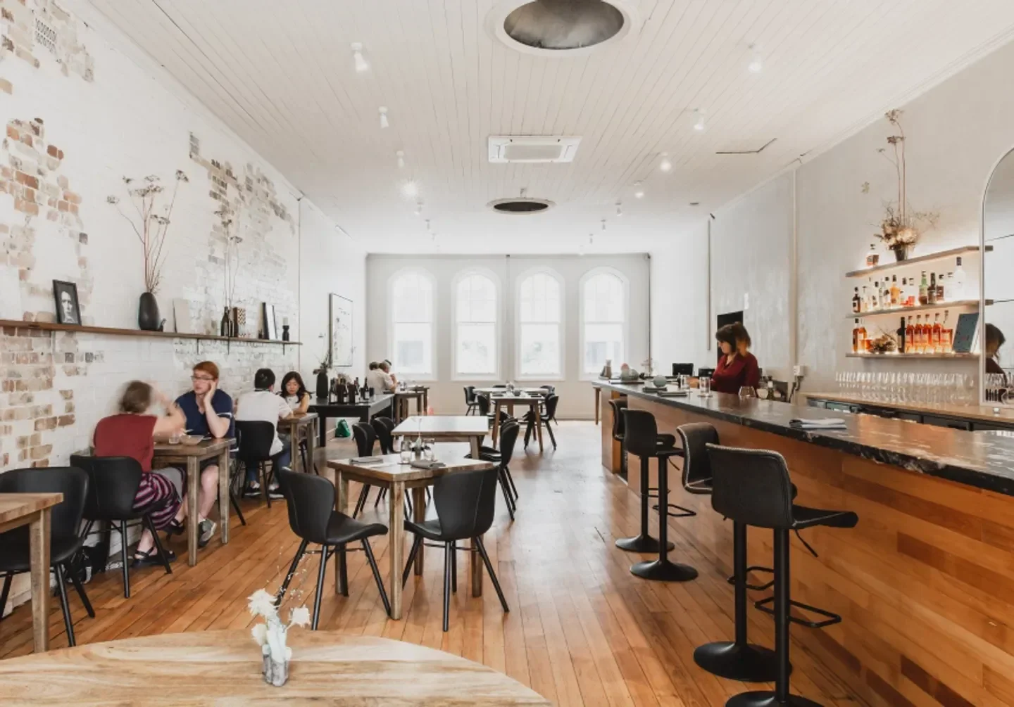 Interior of Pneuma restaurant in Brisbane, featuring dining tables and a bar.