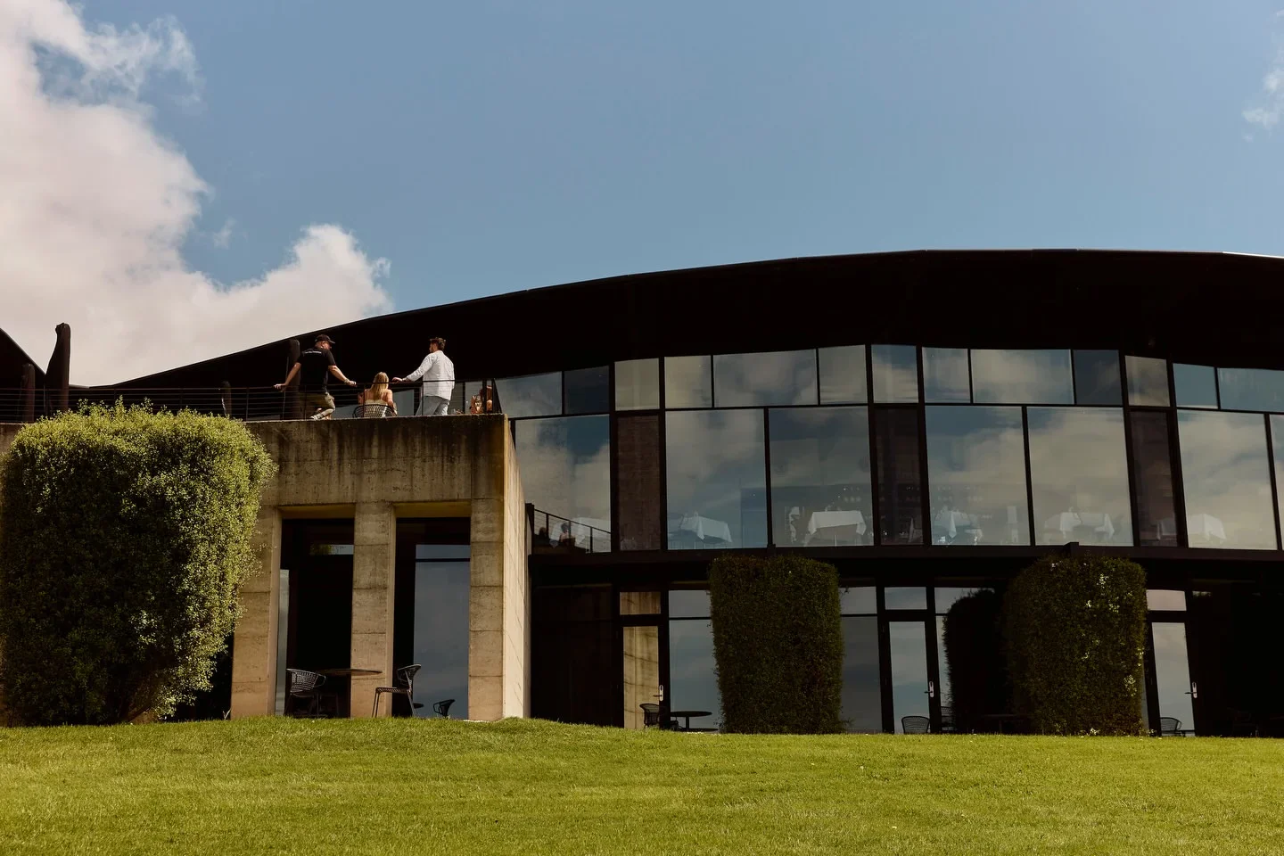 Exterior view of Port Phillip Estate Dining Room on the Mornington Peninsula, a modern restaurant with outdoor seating and a sunny day.