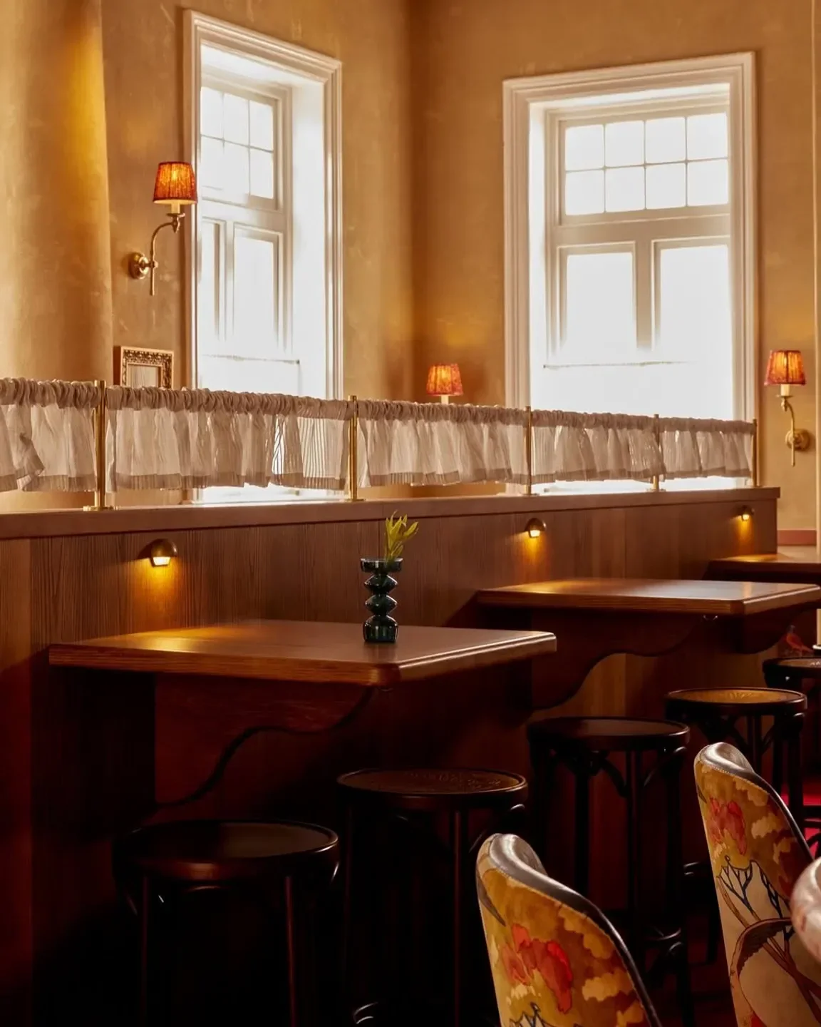 Cozy interior of Postino Osteria in Sydney, featuring wooden tables and intimate seating.