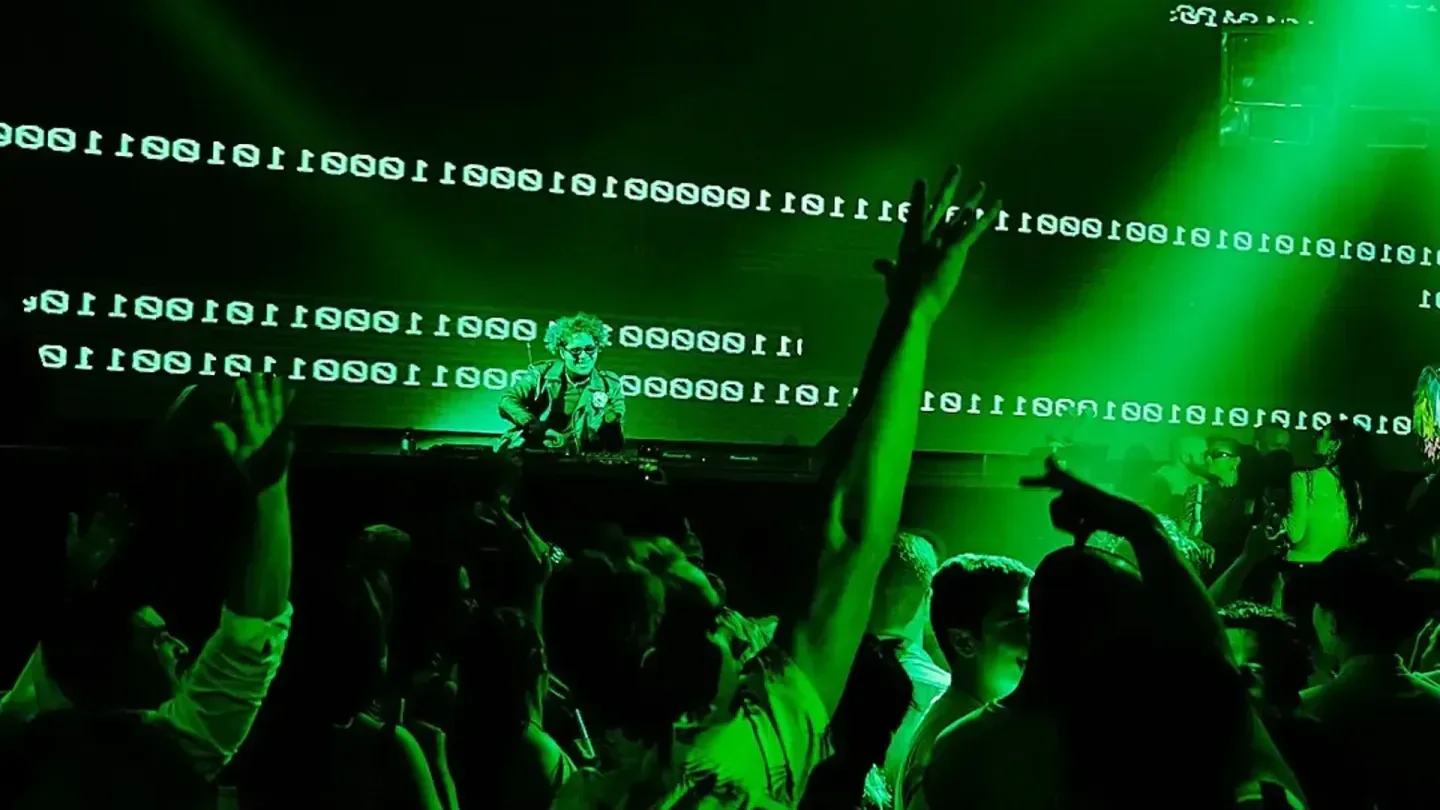 Premier Nightclub in Atlantic City, with a DJ and crowd lit in vibrant green.
