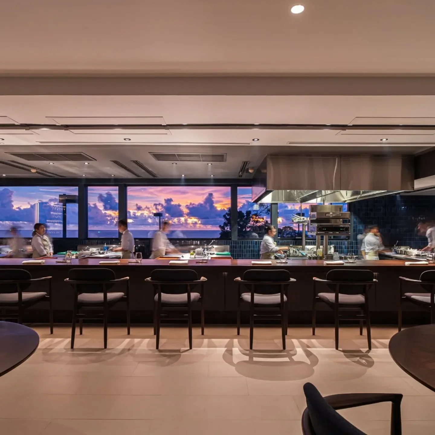 PRU restaurant in Phuket: interior with open kitchen and sunset view.