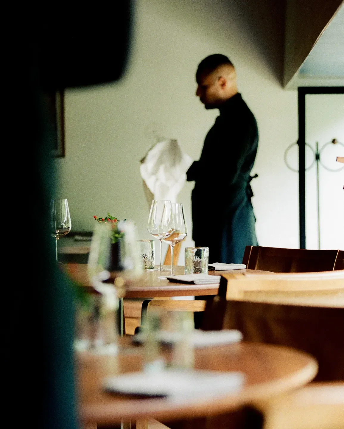 Dining room at Pujol in Mexico City with glasses and server in the background