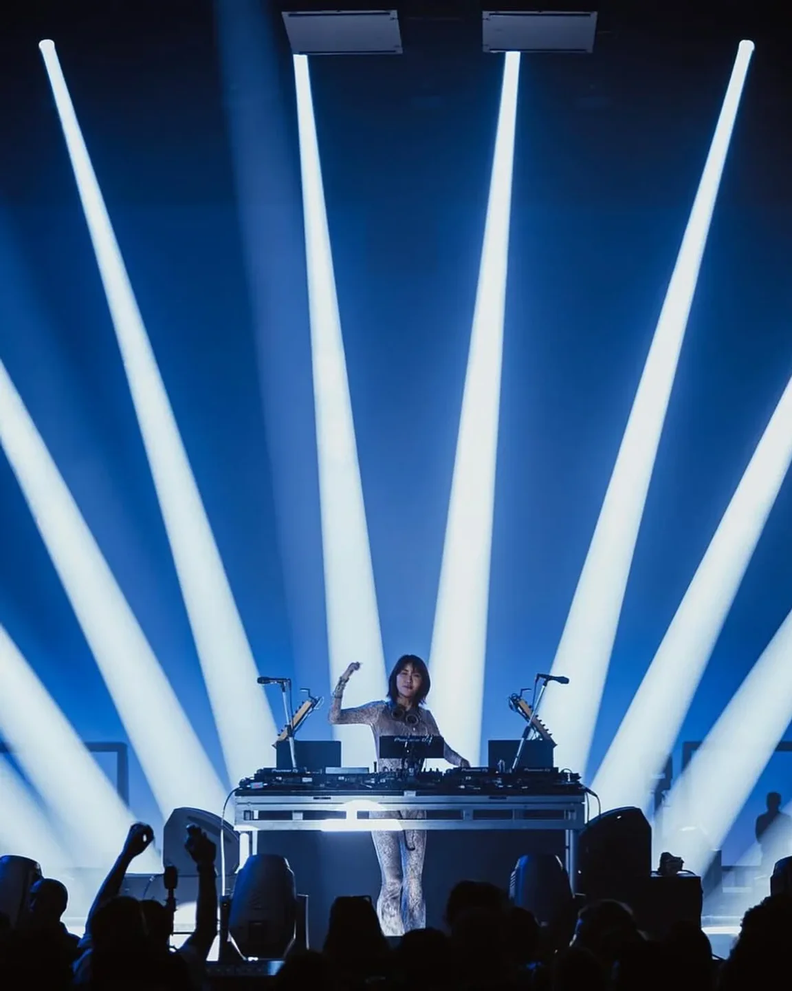 DJ performing with vibrant stage lighting at Q Nightclub in Seattle, creating an energetic ambiance for the crowd.