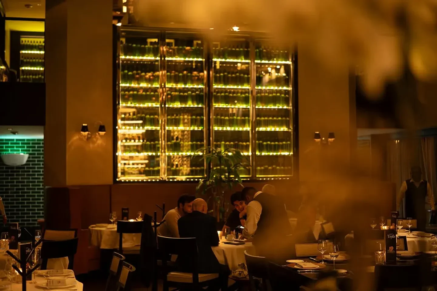 Elegant dining scene at Quattro restaurant in Mexico City with bottle display.