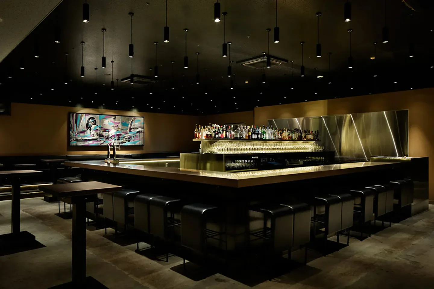 Stylish bar interior at R2 Supper Club in Tokyo with modern art and dim lighting.