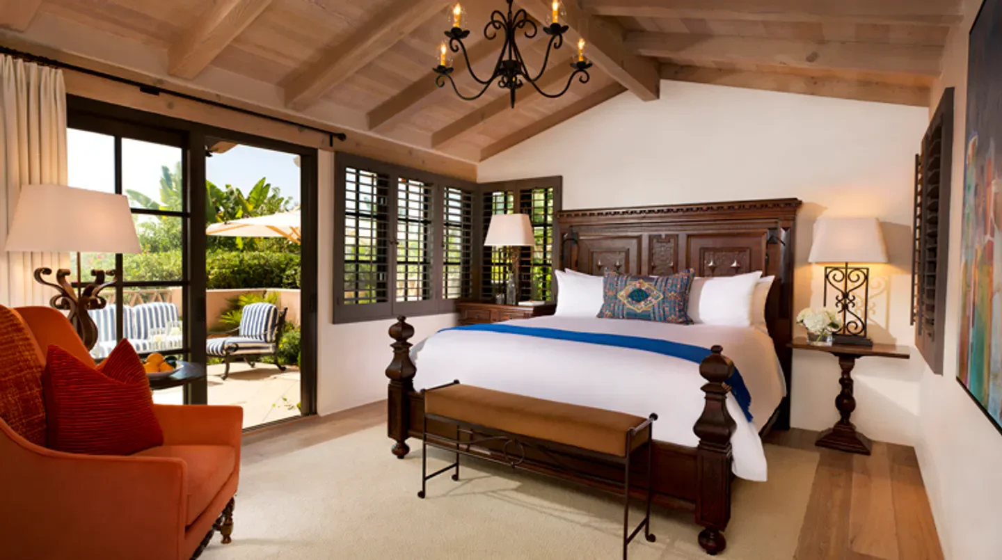Elegant bedroom at Rancho Valencia Resort & Spa in San Diego with open patio access.