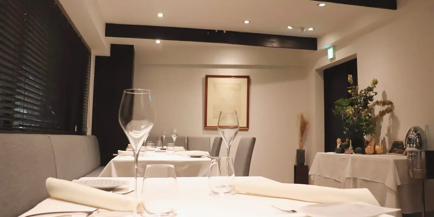Elegant dining room interior at Recte restaurant in Tokyo, with tables set for dinner