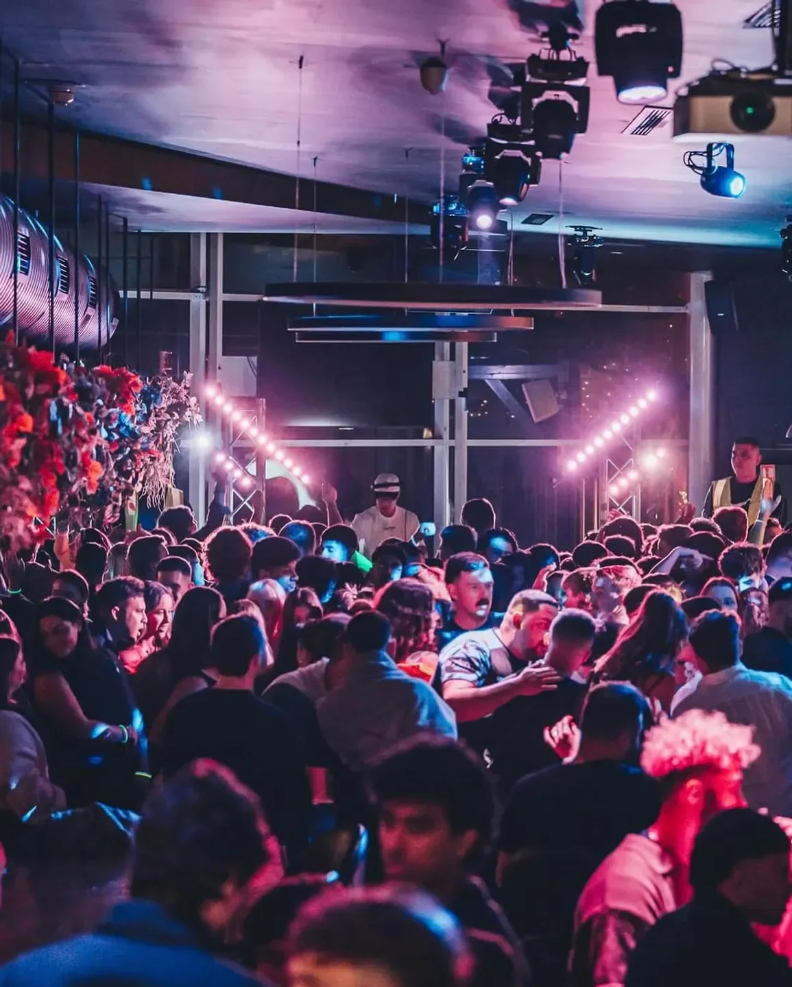 Energetic crowd at Red Room nightclub in Sydney, with stage lights and DJ.