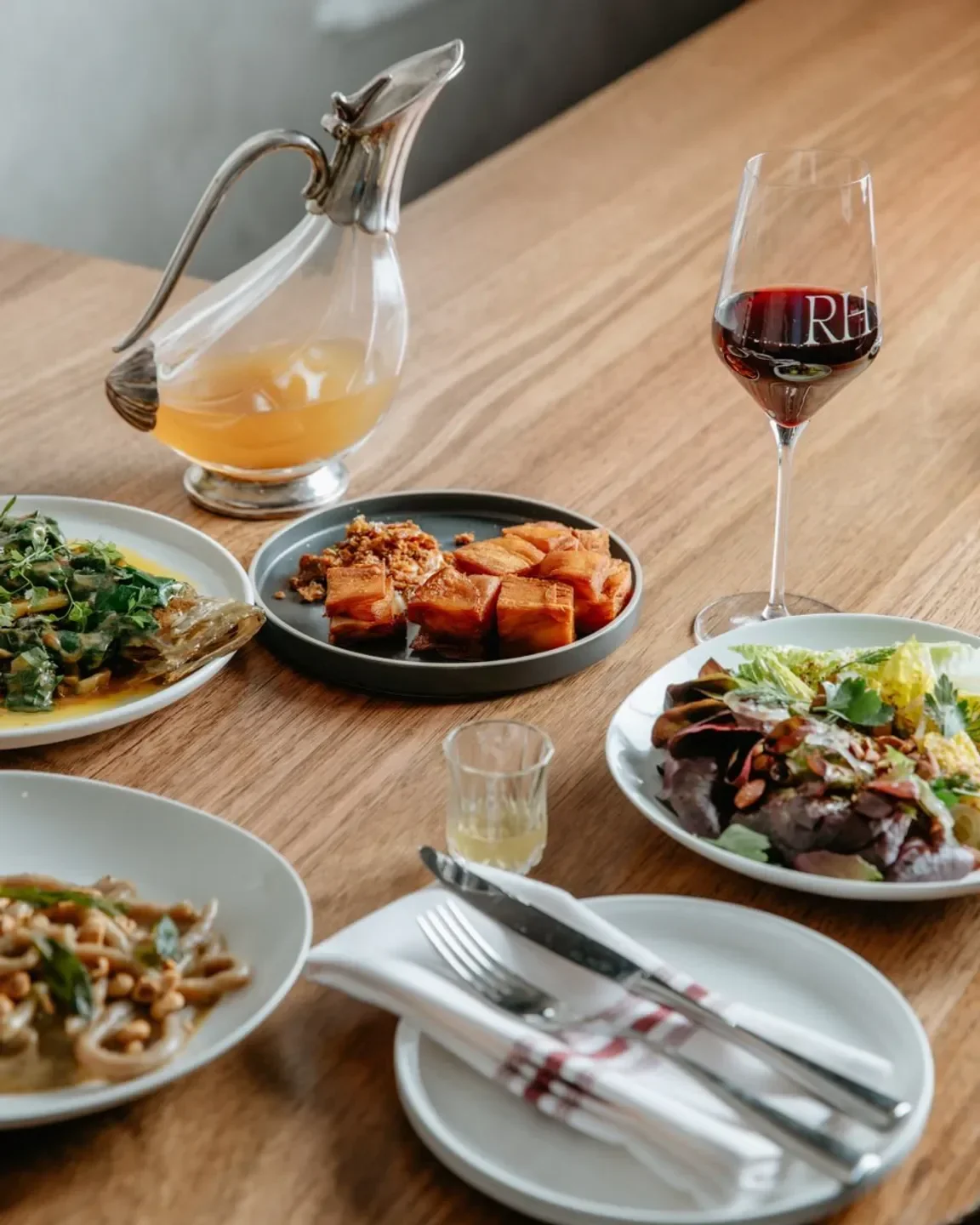 Delicious dishes and wine glass at Reed House in Melbourne, ready for a fine dining experience.
