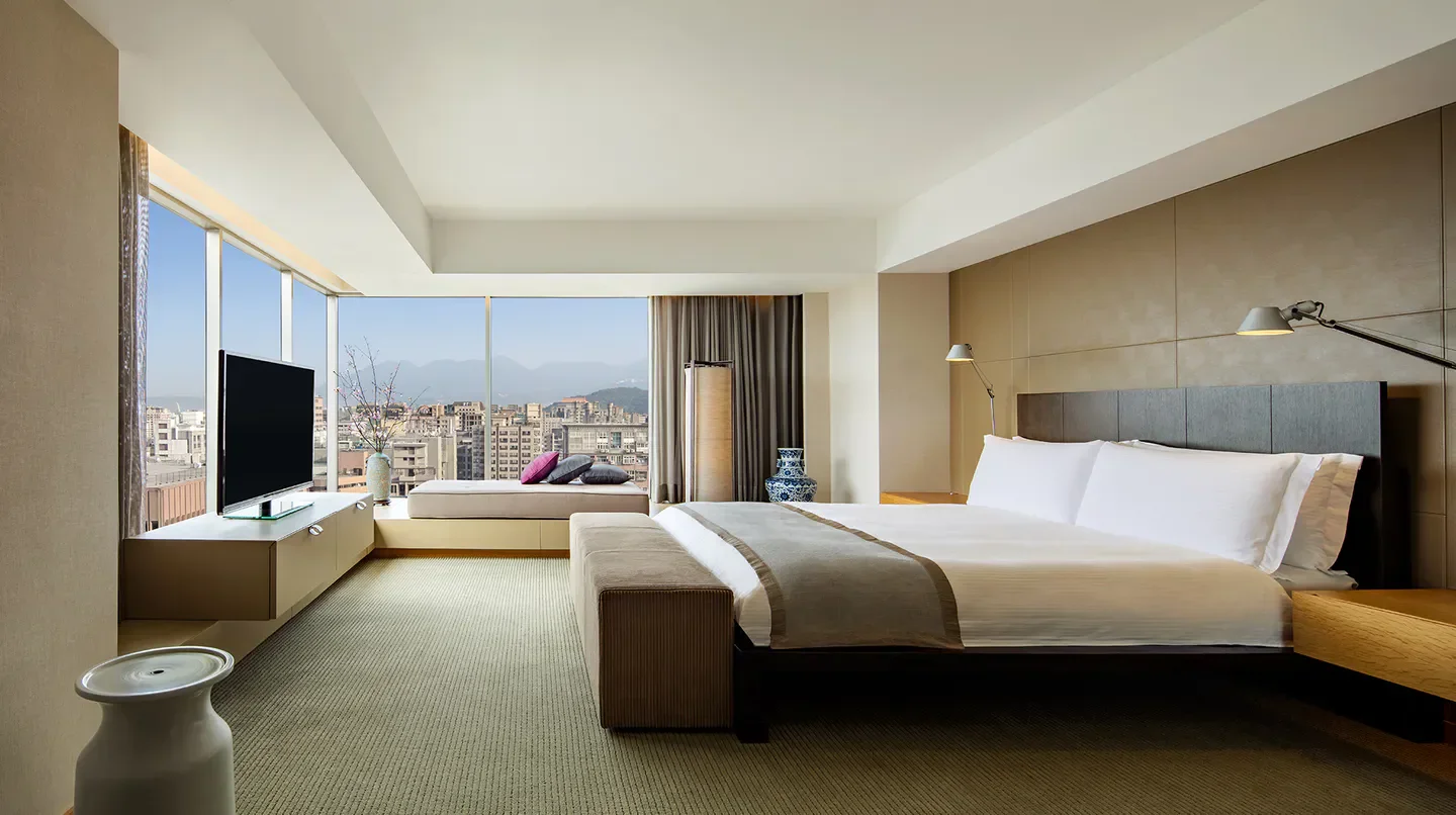 Spacious bedroom at Regent Taipei with a stunning view of Taipei city and mountains