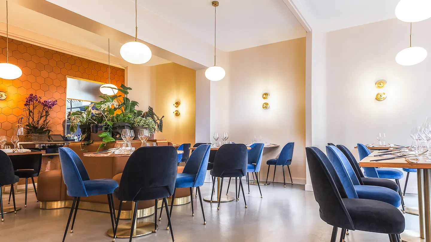 Elegant dining room interior at Restaurant Oxte in Paris, featuring stylish blue chairs