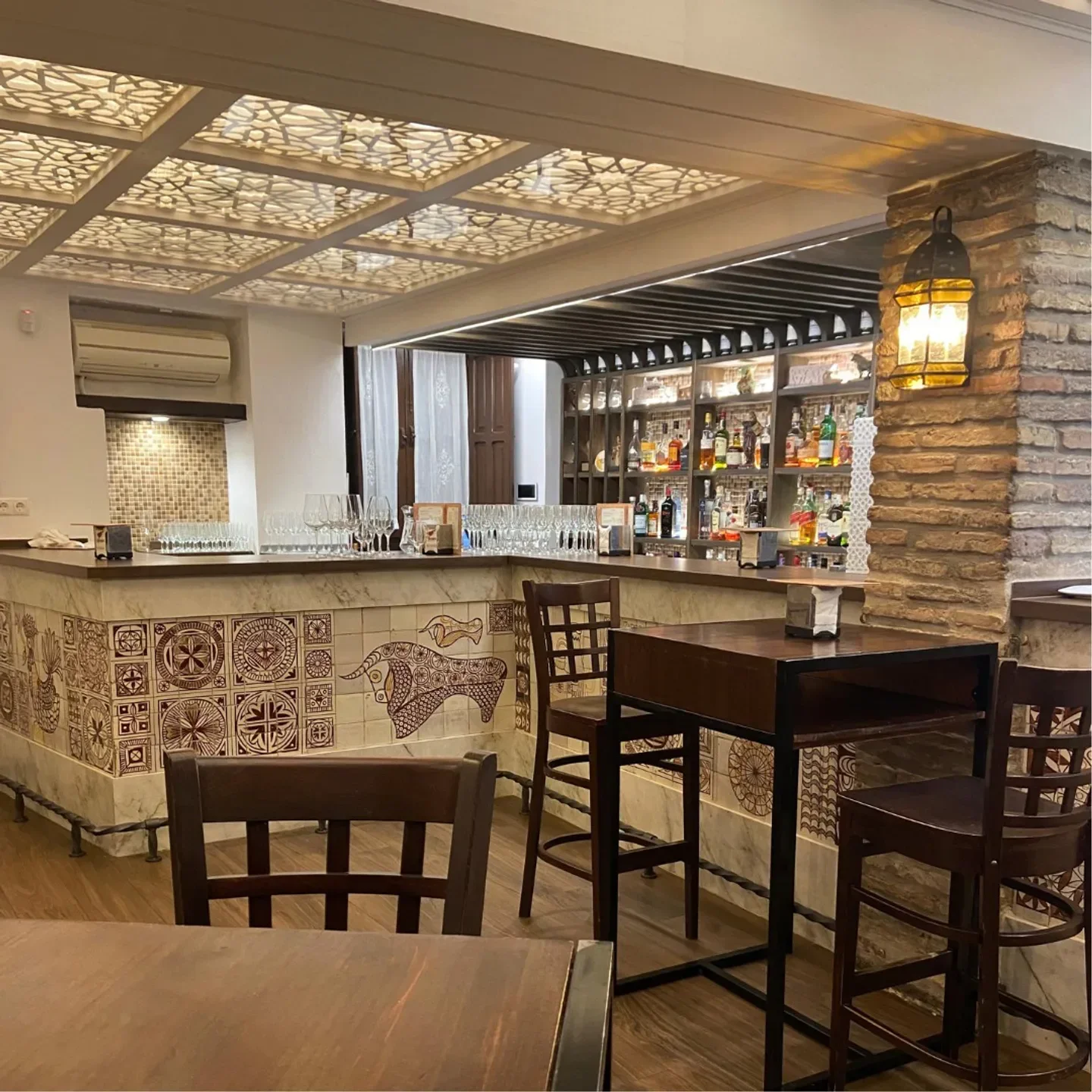 Elegant bar interior at Restaurante El Churrasco in Andalusia, showcasing a warm and inviting atmosphere.