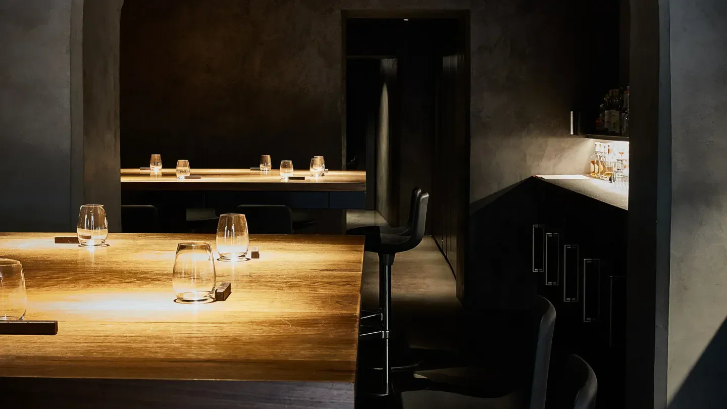 Interior of Retrobottega restaurant in Rome, showcasing elegant wooden tables and dimly lit ambiance.