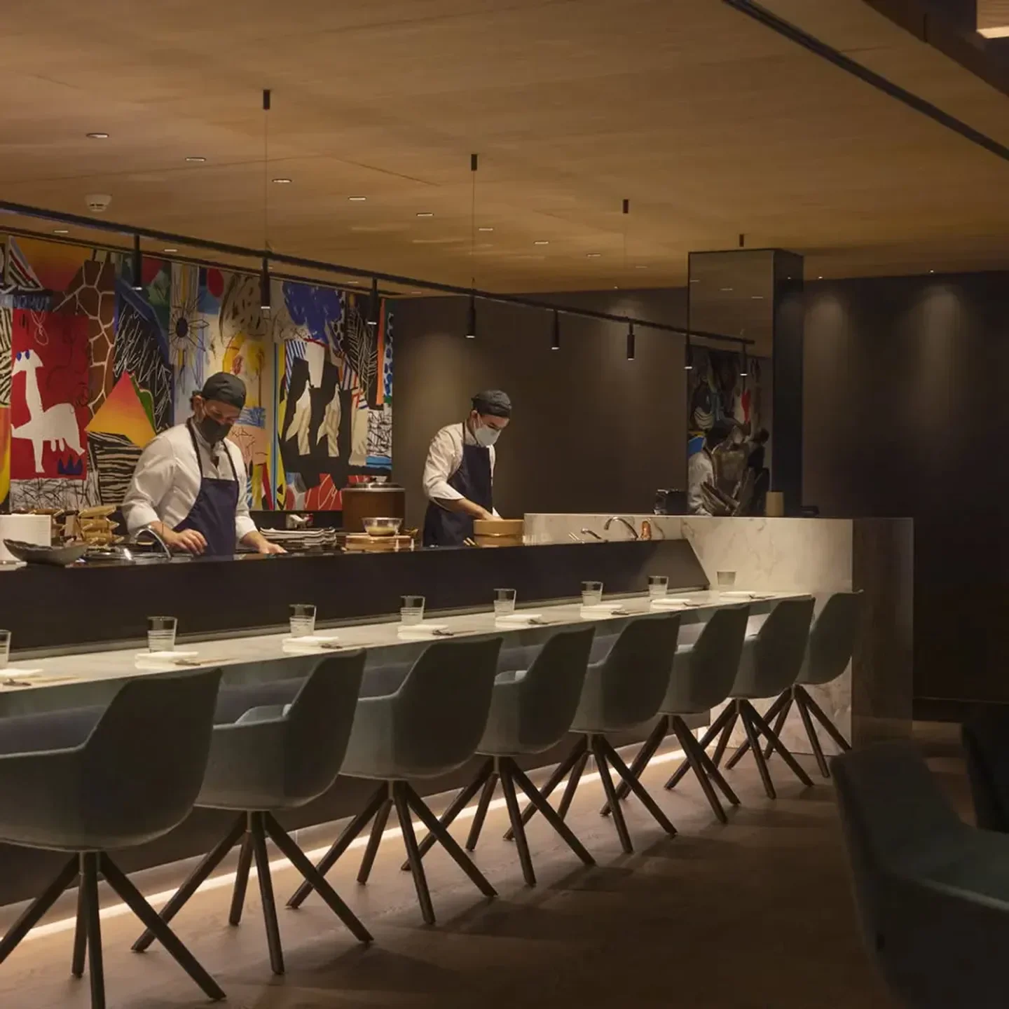 Chefs preparing food at Ricardo Sanz Wellington restaurant in Madrid's elegant dining area.
