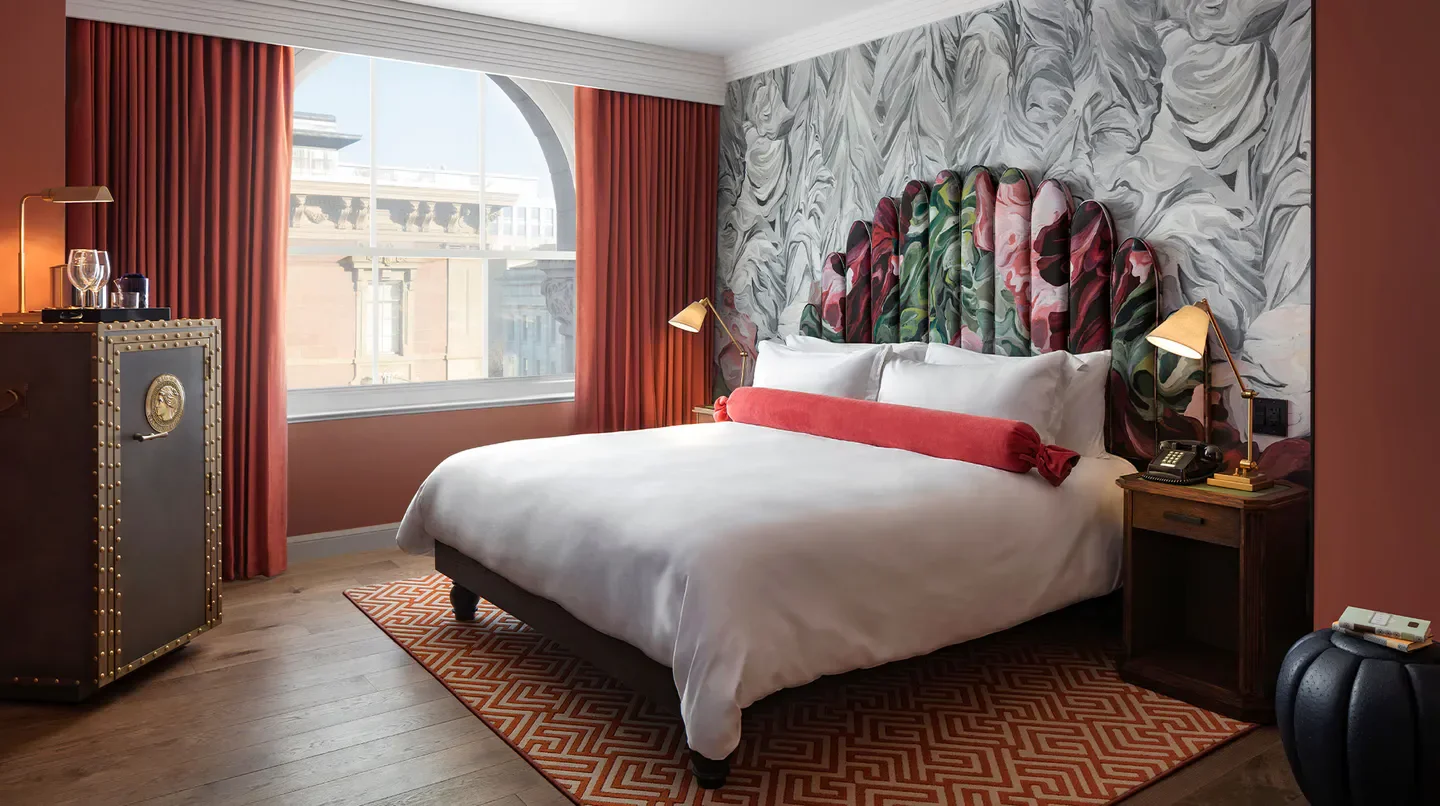 Cozy bedroom in Riggs Washington DC with a floral headboard and city views.