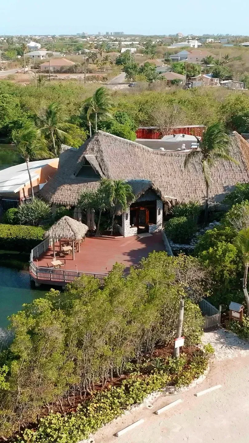 Aerial view of Ristorante Pappagallo in Grand Cayman, with waterfront deck and thatch roof.