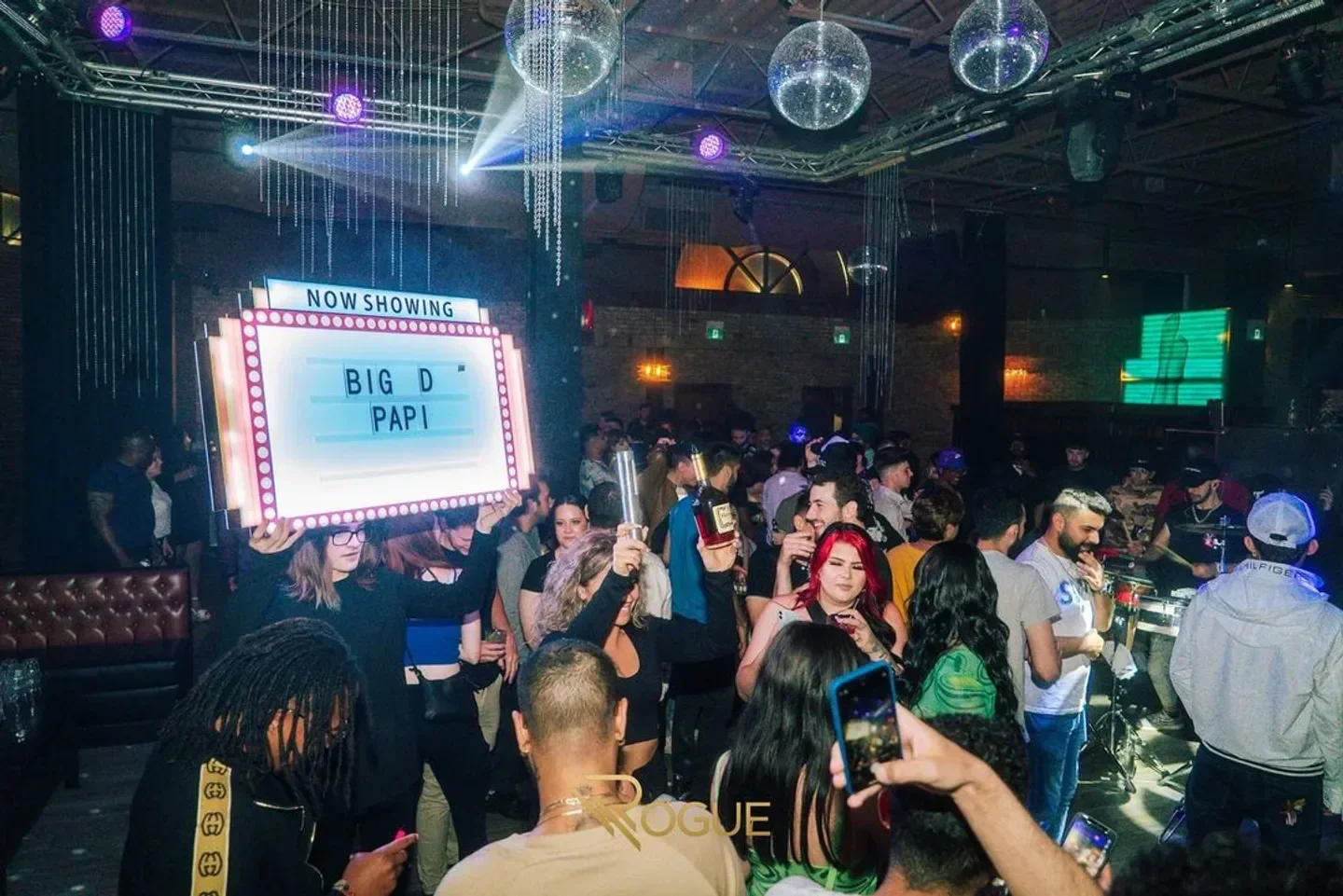 Energetic night at Rogue Nightclub in Toronto with a 'Big D Papi' sign.