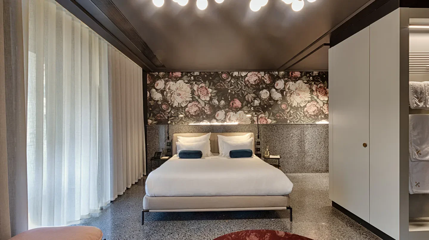 Elegant bedroom at Rosselli - AX Privilege in Malta, featuring floral wallpaper and large bed.