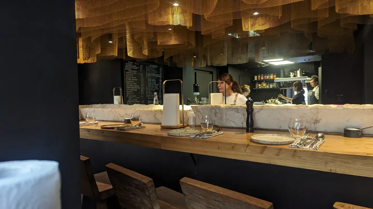 Interior of Rybtorg restaurant in Moscow: bar with hanging decor and kitchen view.