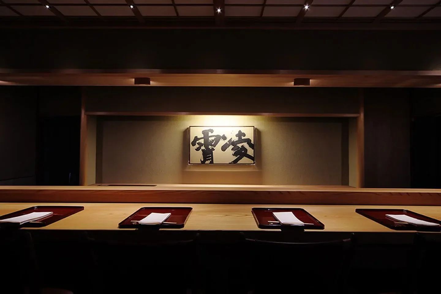 Interior of Ryō-shō restaurant in Kyoto, featuring a minimalist wooden sushi bar