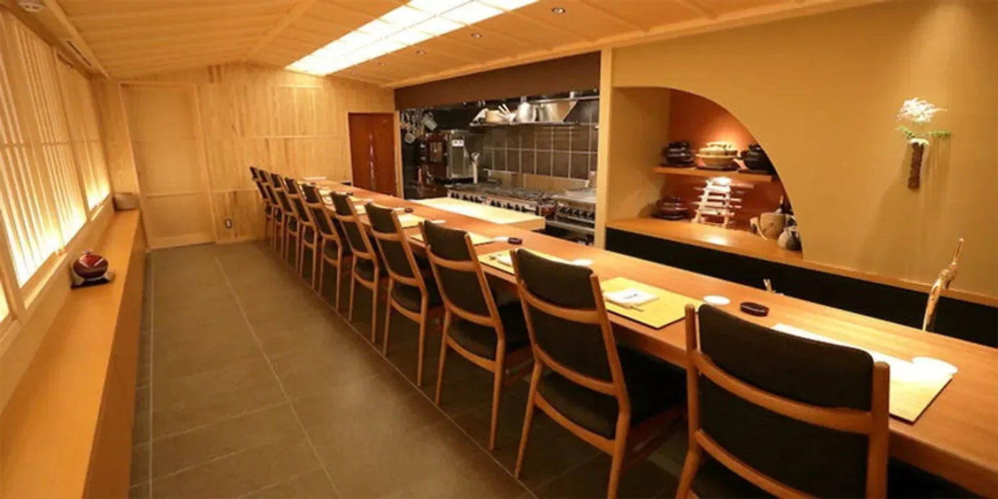 Interior of Ryoriya Maekawa in Kyoto, showcasing the bar seating area and open kitchen.