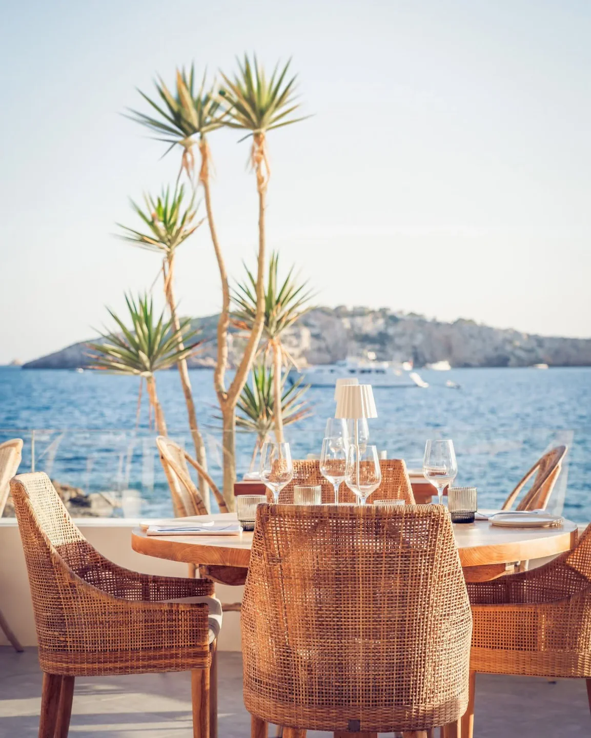 Sa Punta restaurant offers waterfront dining with rattan chairs and a scenic view of the city and sea.
