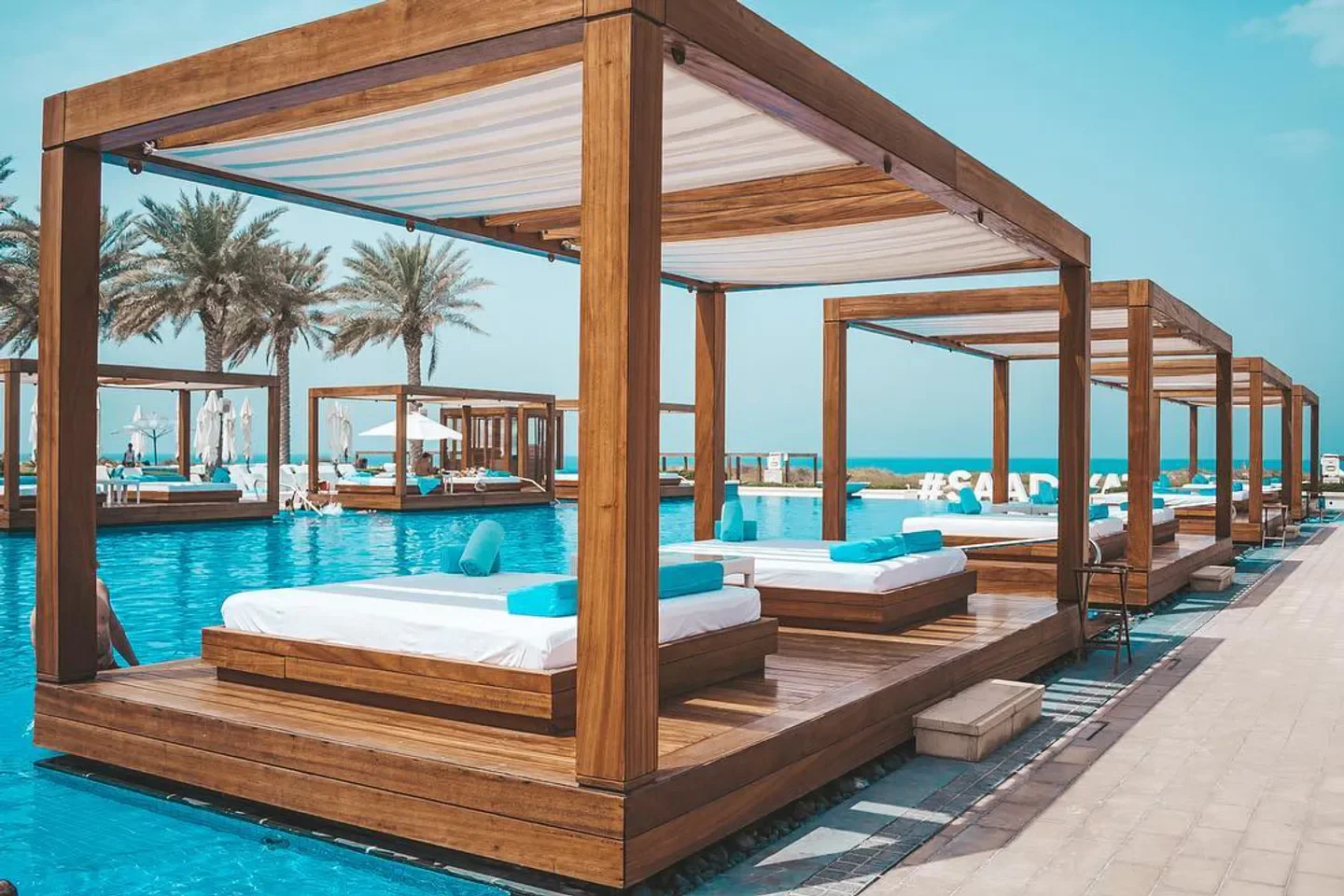 Luxury cabanas at Saadiyat Beach Club in Abu Dhabi, overlooking a stunning pool.