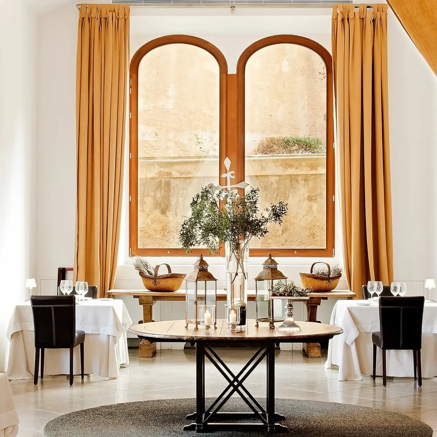 Elegant dining room interior at Saddle restaurant in Madrid, with a large window.