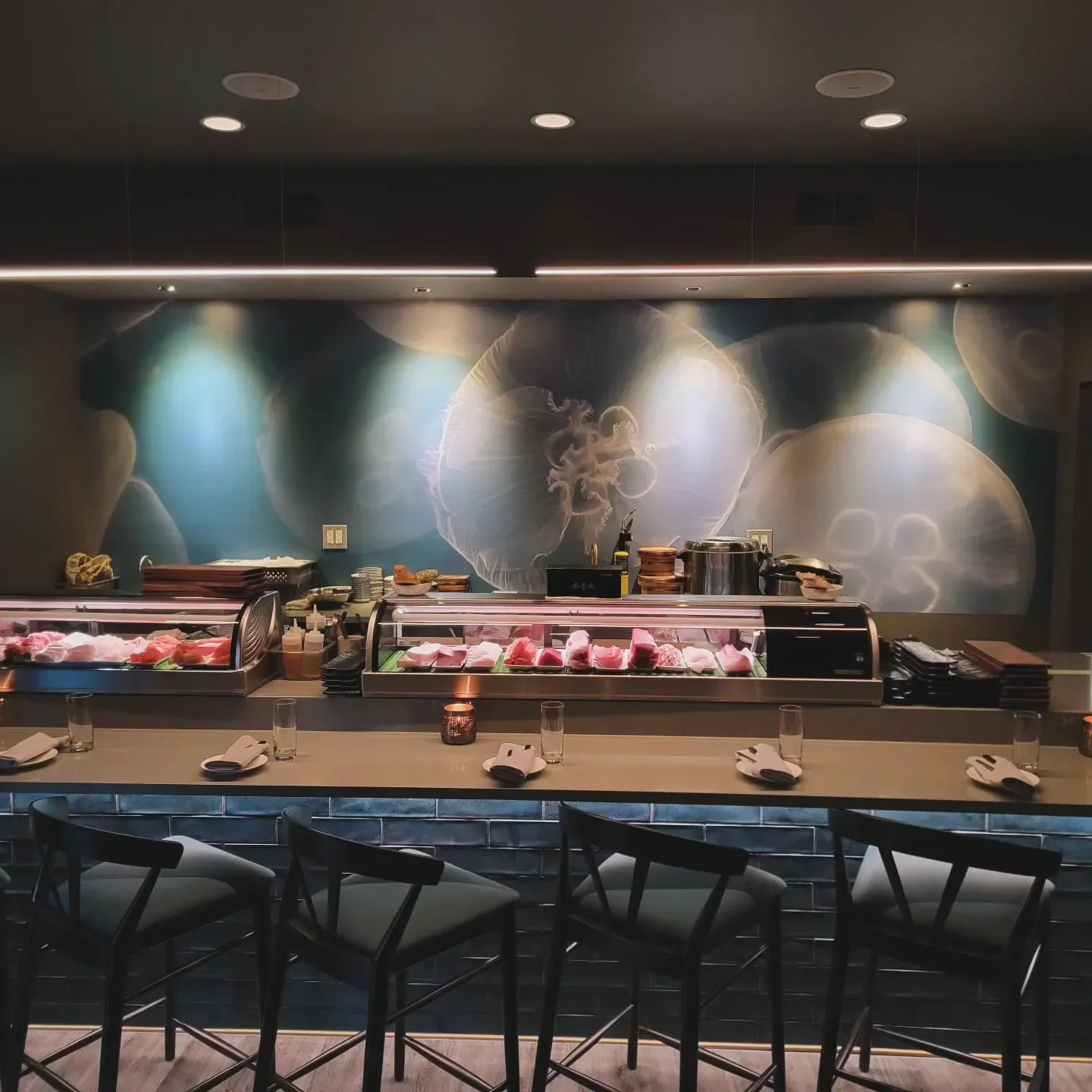 Interior of SADO restaurant in St. Louis, with sushi bar and decorative jellyfish mural.