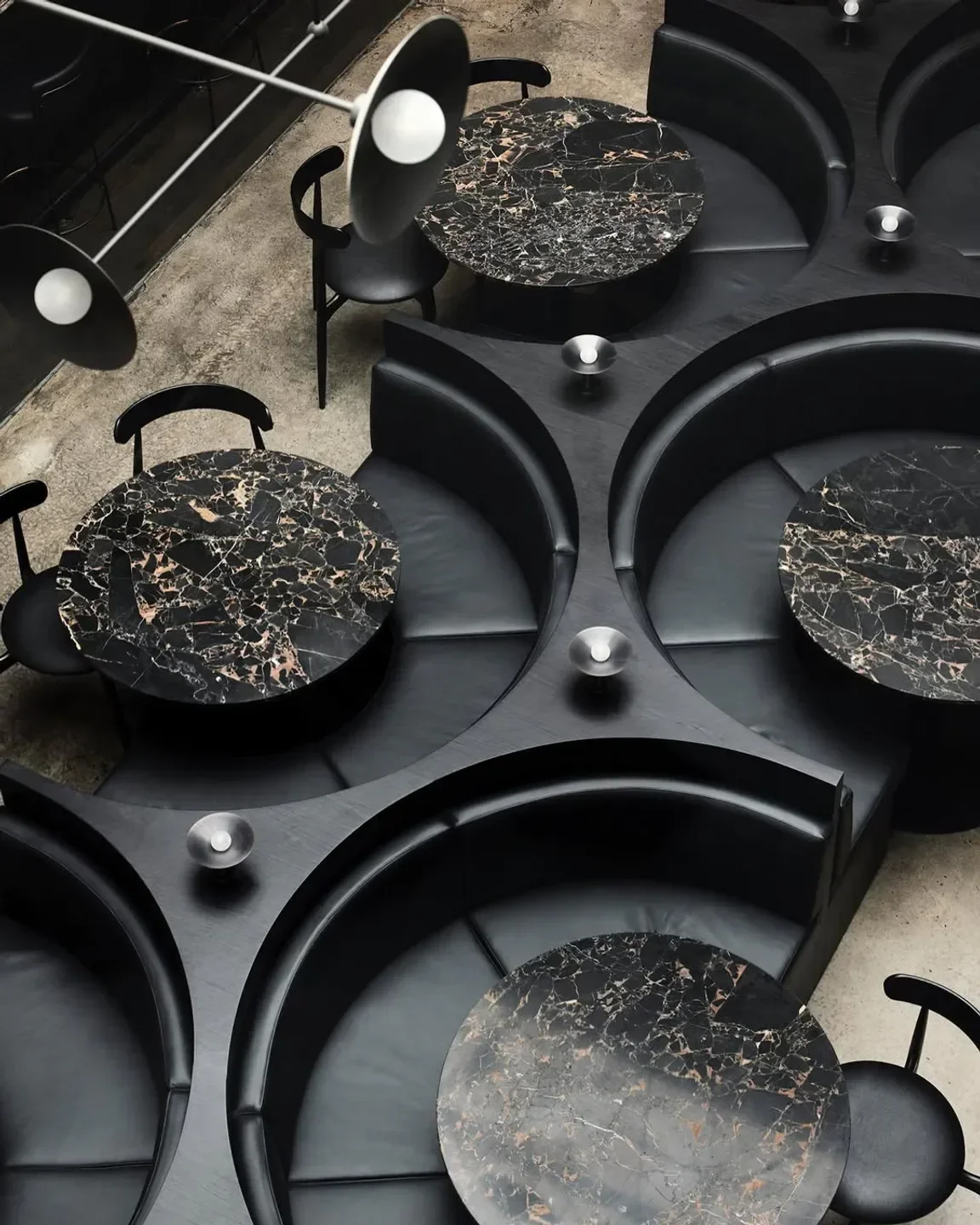 Stylish interior dining area at Saint Hotel in Melbourne featuring marble tables and booths.