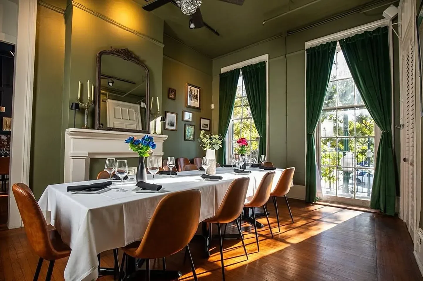 Elegant dining room at Saint John in New Orleans, with a view through large windows.