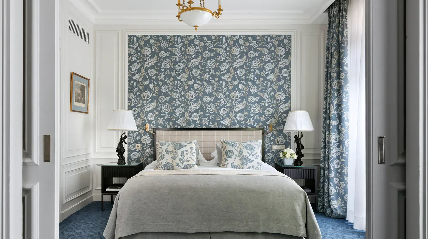 Elegant bedroom at San Régis Paris hotel with floral wallpaper, a luxurious stay in Paris.
