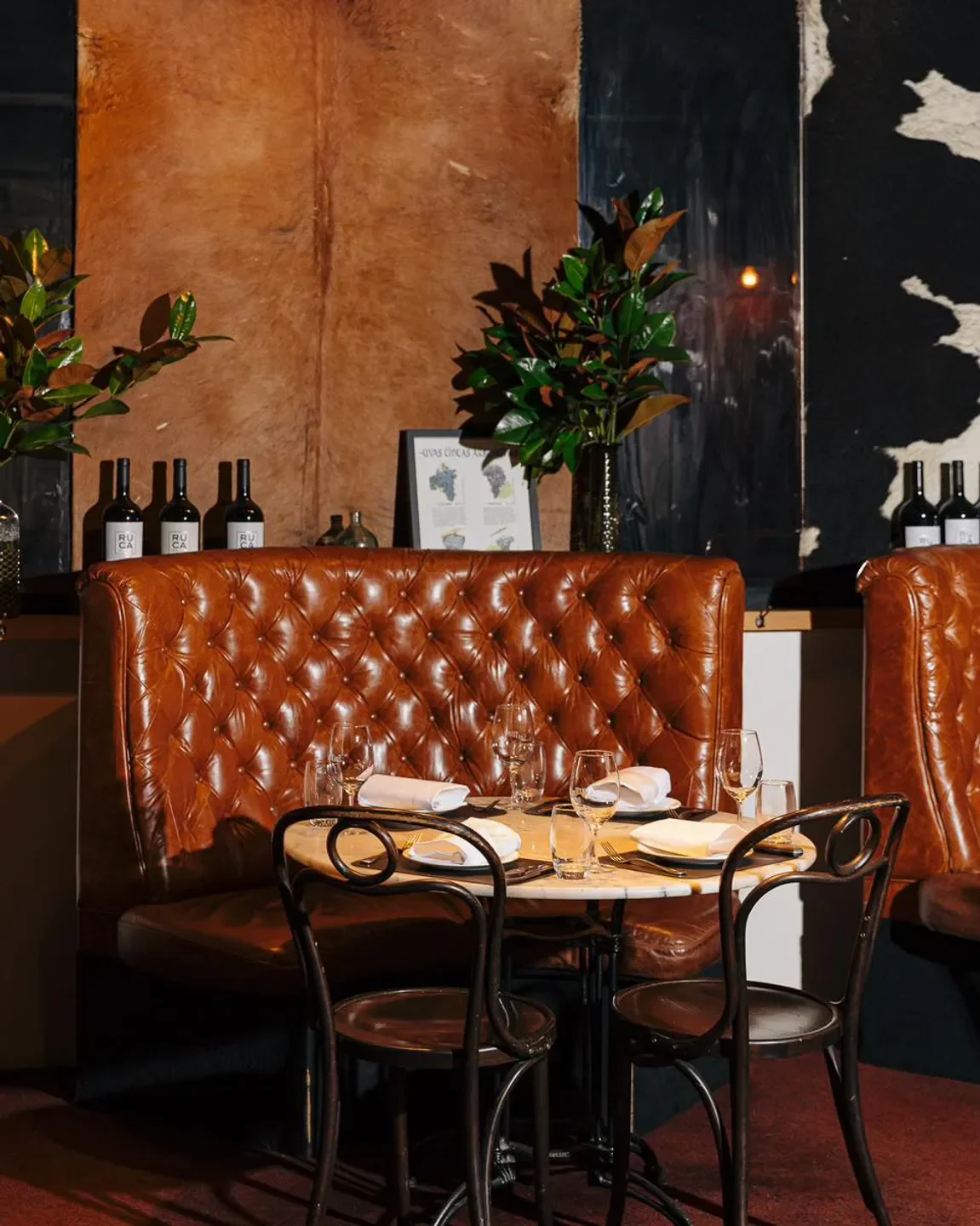 Cozy dining setting at San Telmo restaurant in Melbourne, featuring leather booth seating.
