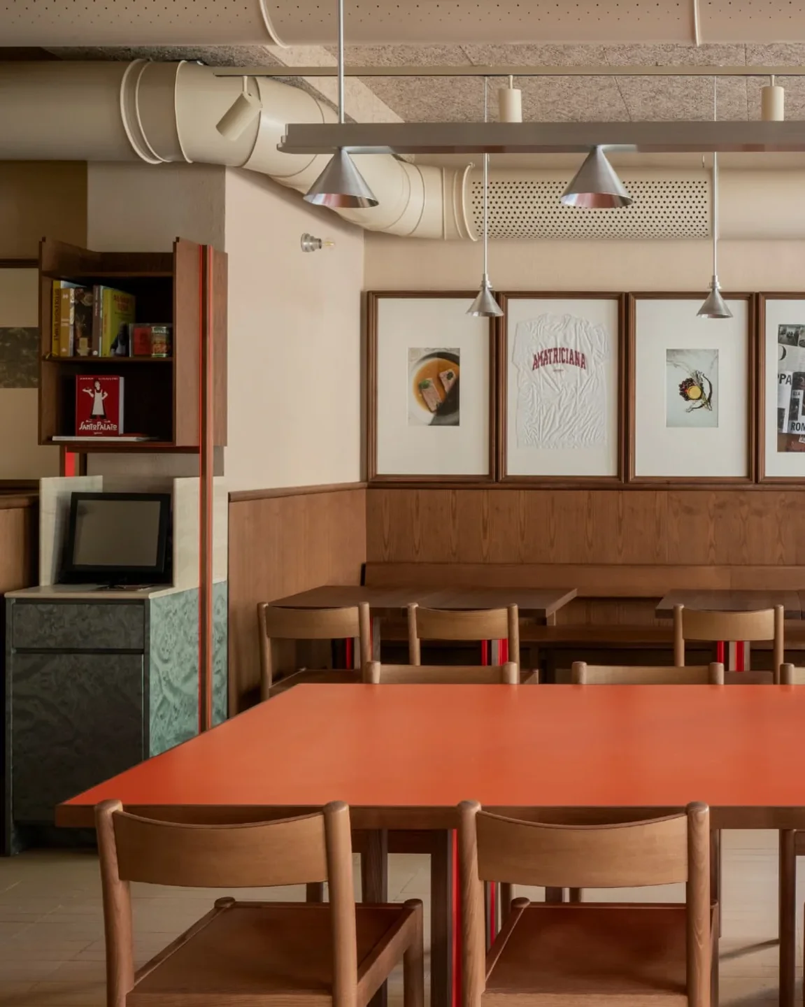 SantoPalato restaurant interior in the city, featuring an orange table and wooden chairs.