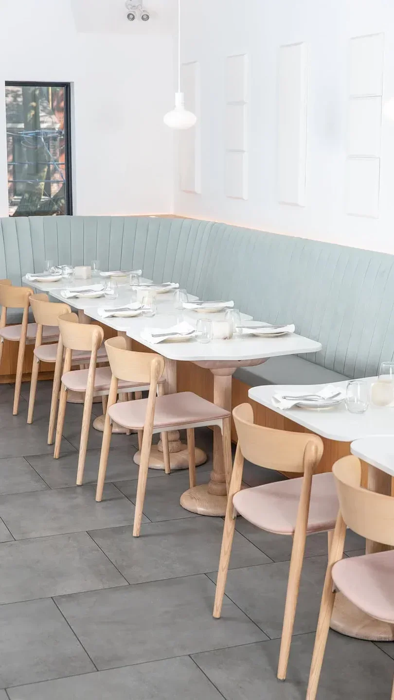 Interior of SARA restaurant in Toronto, with stylish tables and seating arrangements.