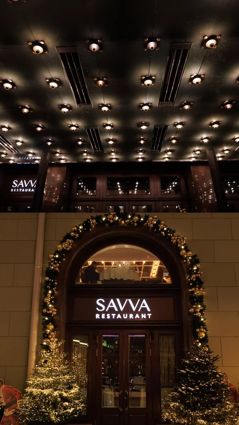Exterior of Savva restaurant in Moscow at night, with festive decorations and Christmas trees.