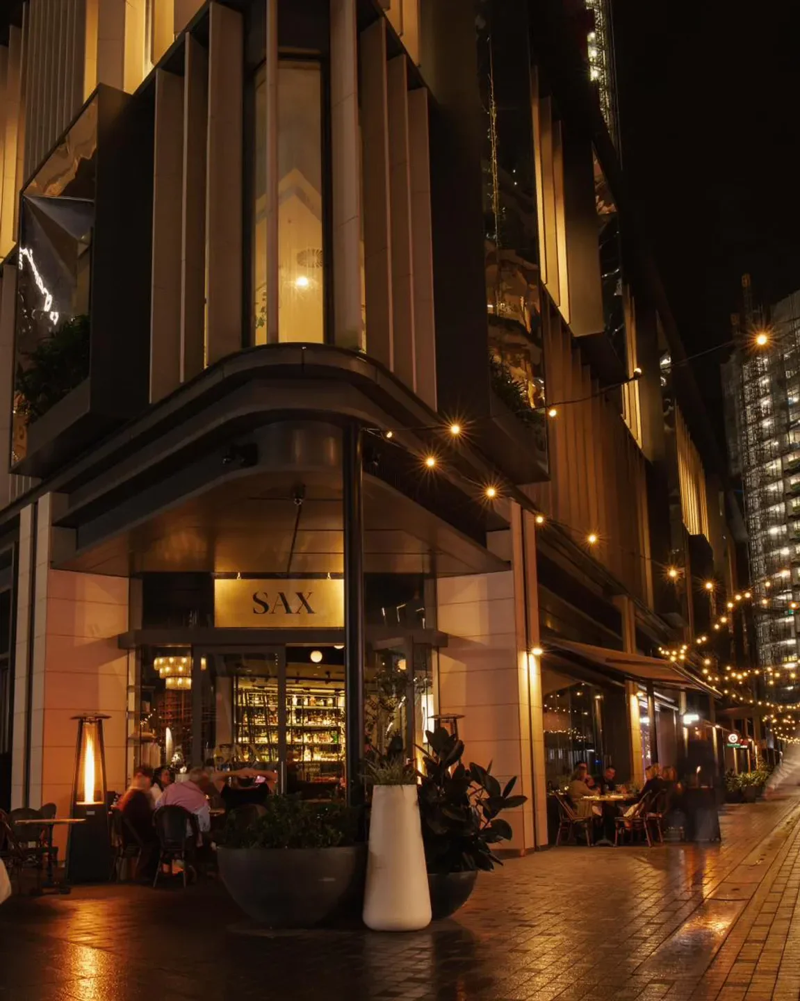 Sax Café & Lounge Bar in Sydney at night, outdoor dining and glowing lights.