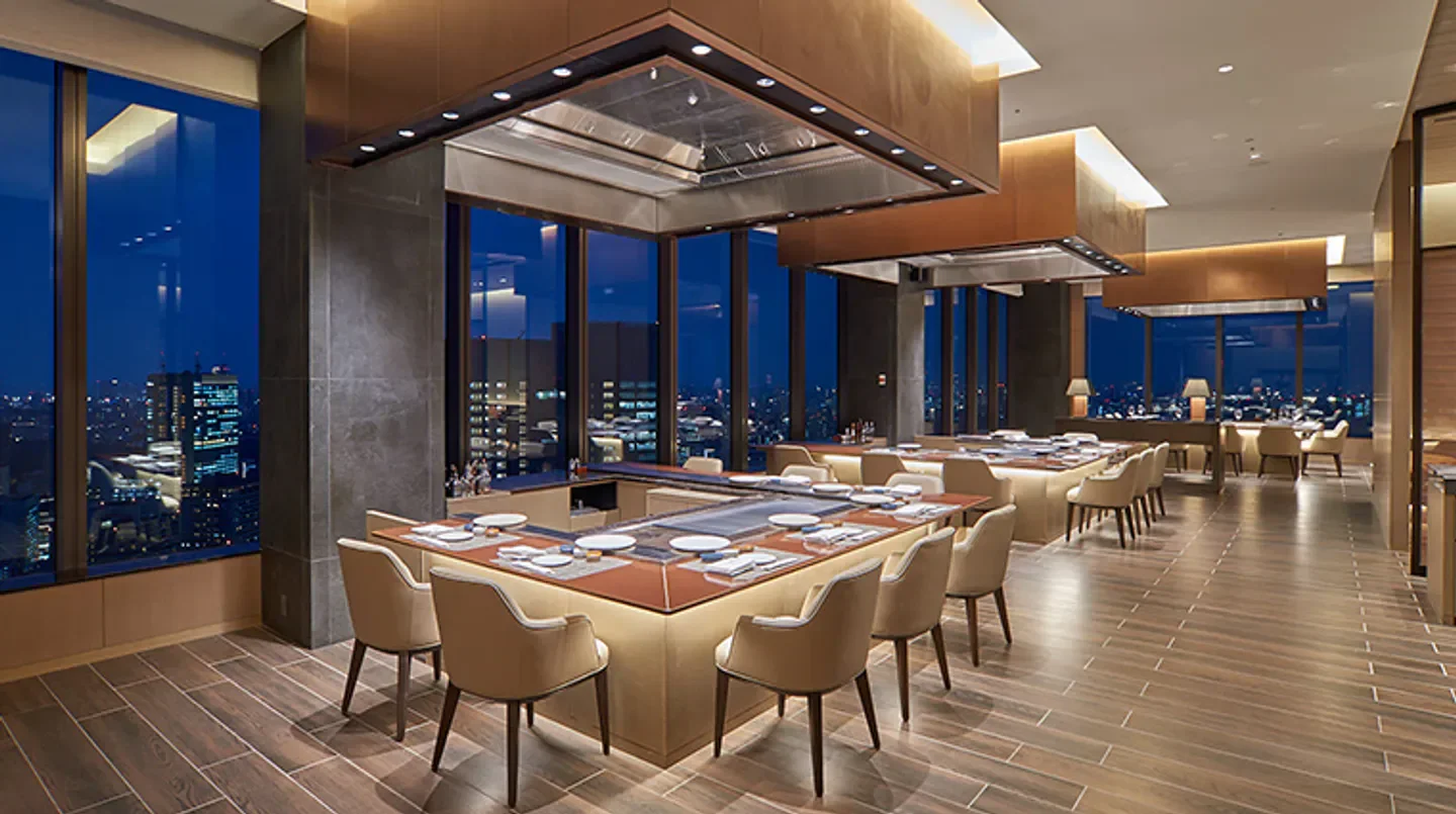 Elegant dining room at Sazanka in Tokyo with city views at night.
