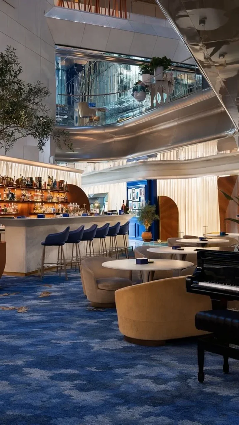 Stylish bar area and seating at Scalini restaurant in Cannes, featuring blue carpets and elegant decor.