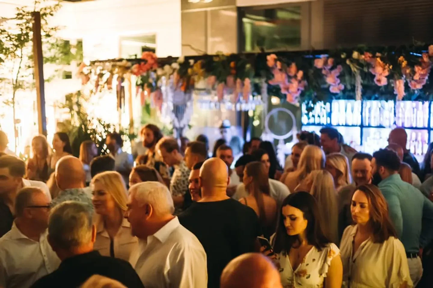 Crowd enjoying a night out at Selavi nightclub in Warsaw, with floral decor.