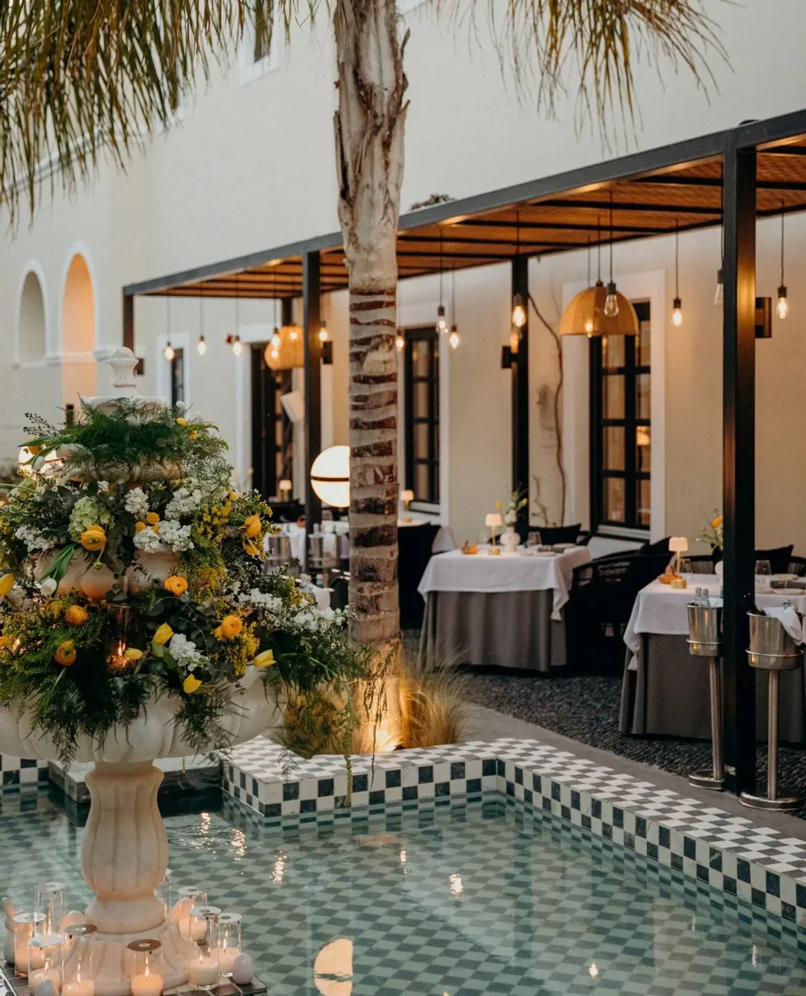 Outdoor dining at Selene restaurant in Santorini, featuring a fountain and stylish ambiance.