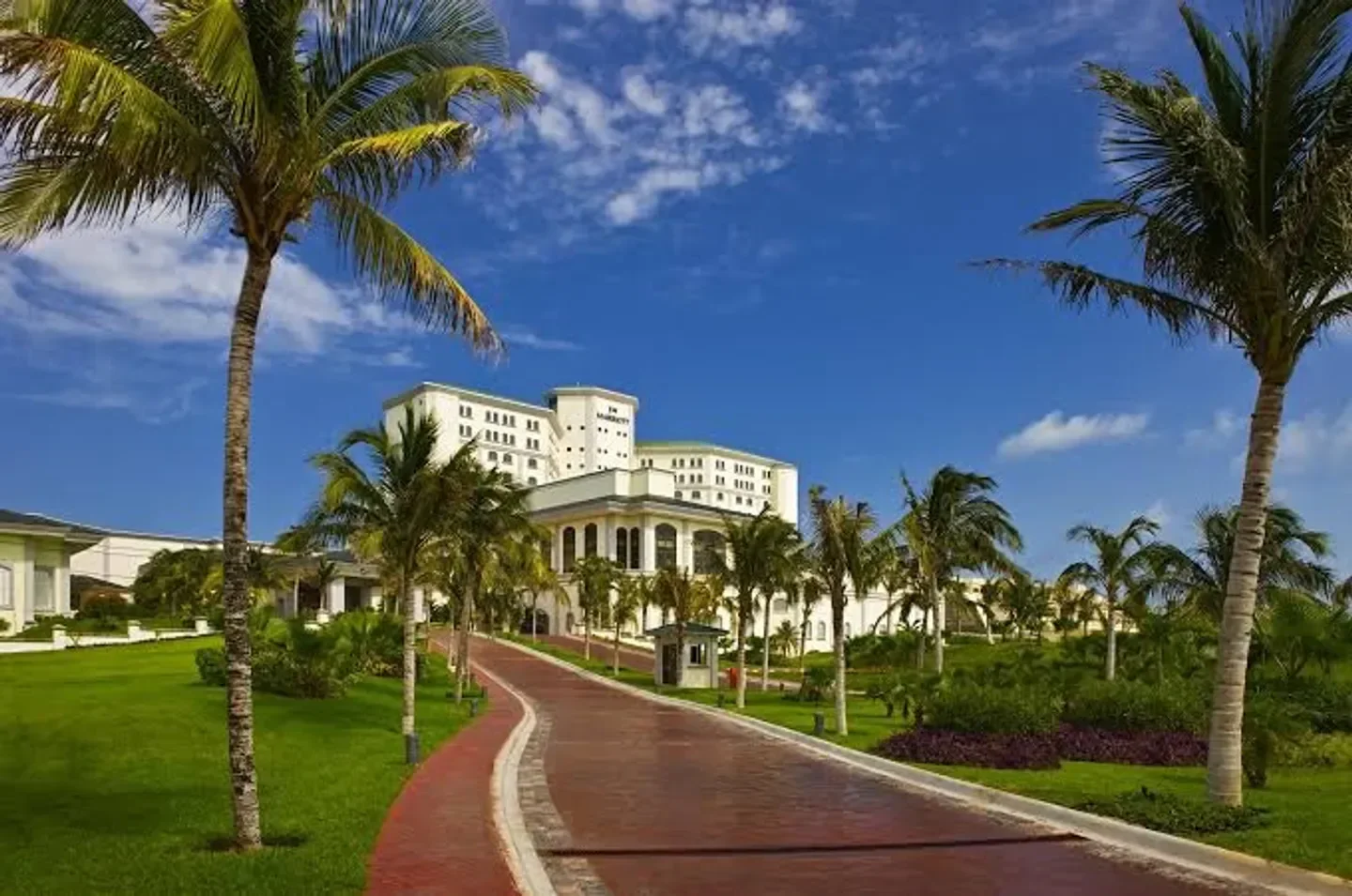 Entrance to Sens-Yah Spa in Cancun, with palm trees and a beautiful resort.