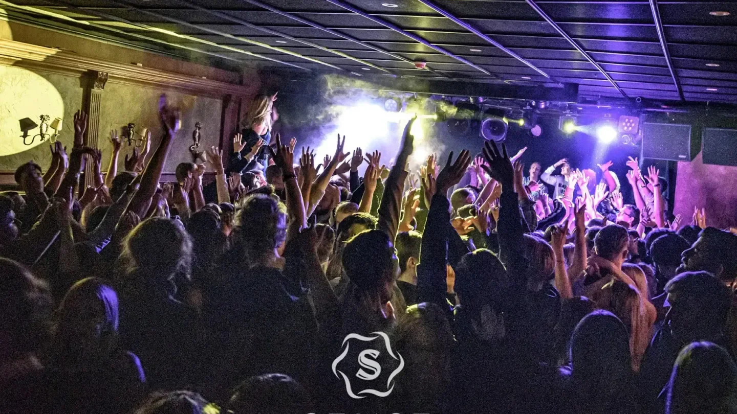 Energetic crowd at Sense nightclub in Stockholm with hands in the air, enjoying the show.