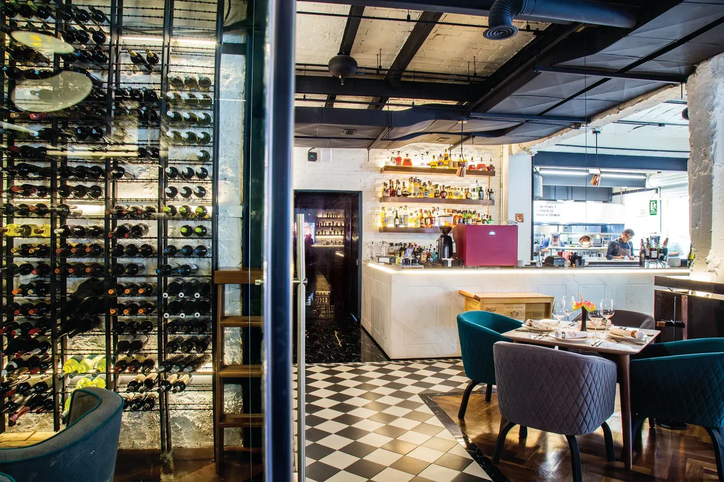 Interior of Sepia restaurant in Mexico City featuring wine rack and elegant seating.