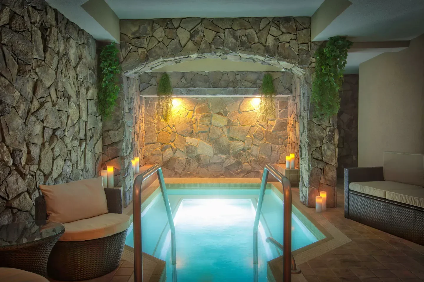 Cozy spa pool at Serenity Spa by Westgate in Park City with stone walls and candles.