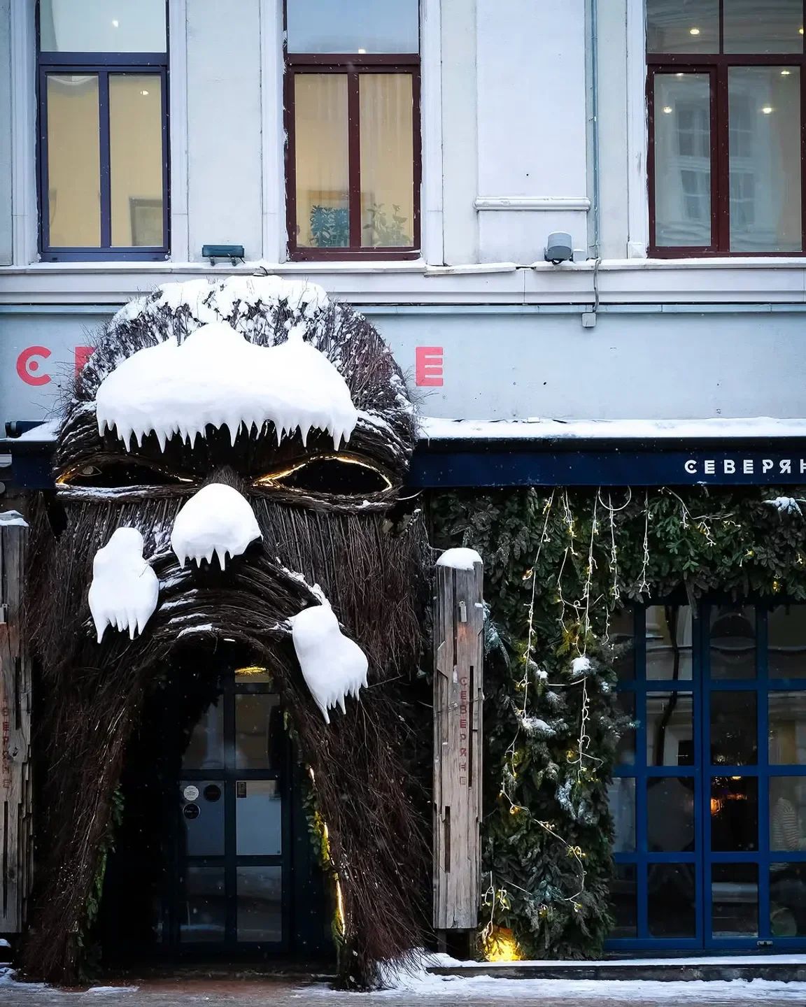 Entrance of Severyane - Северяне restaurant in Moscow, decorated with snow and branches